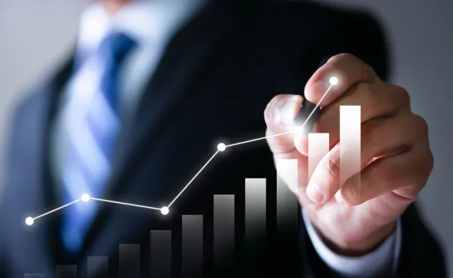 ペンでグラフを描いているスーツ姿の男性